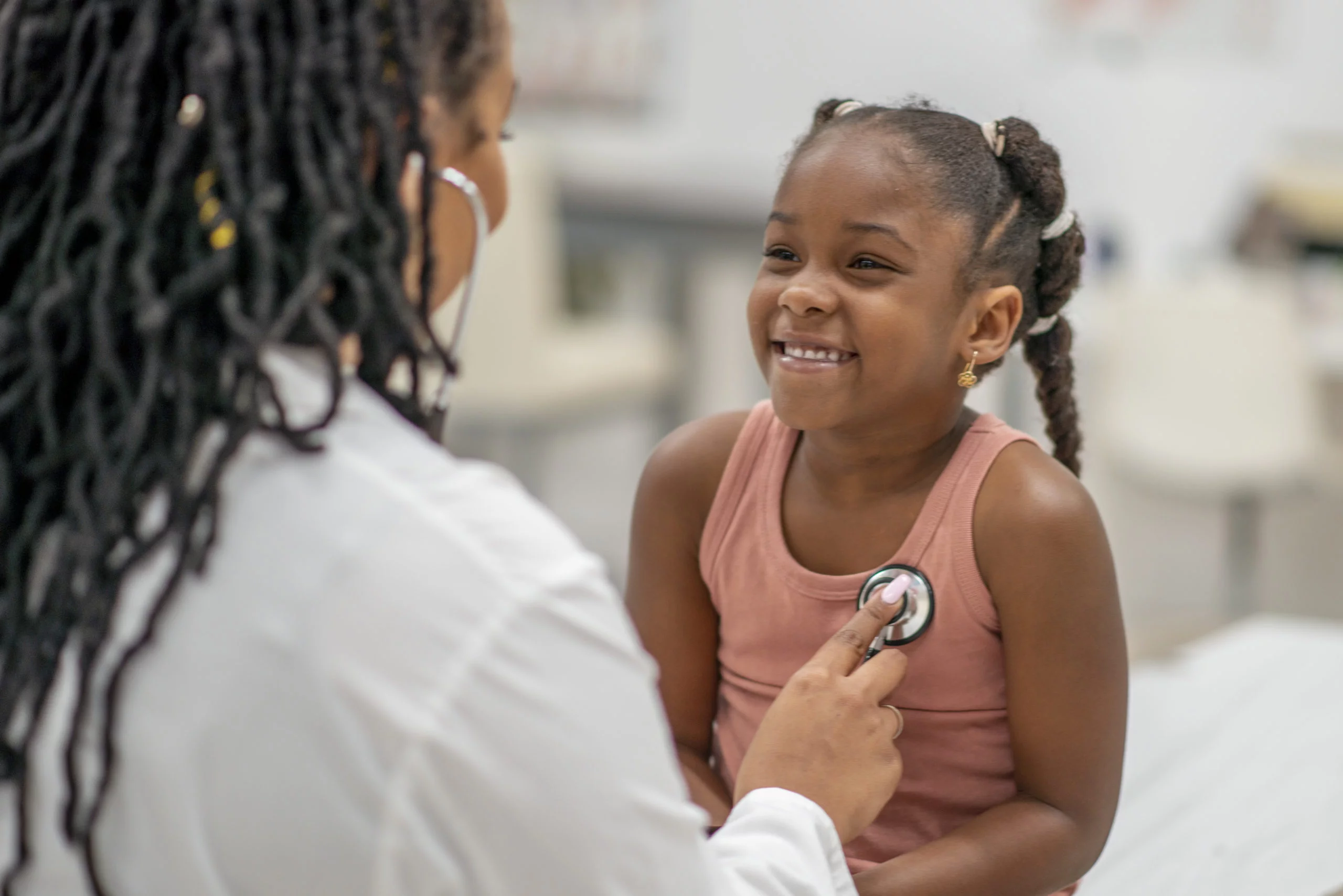 a doctor listening to a girl's heart