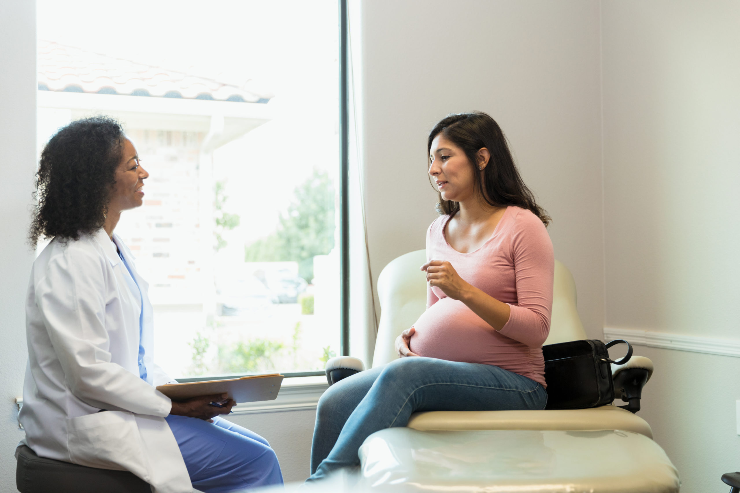 a pregnant woman talking to a doctor